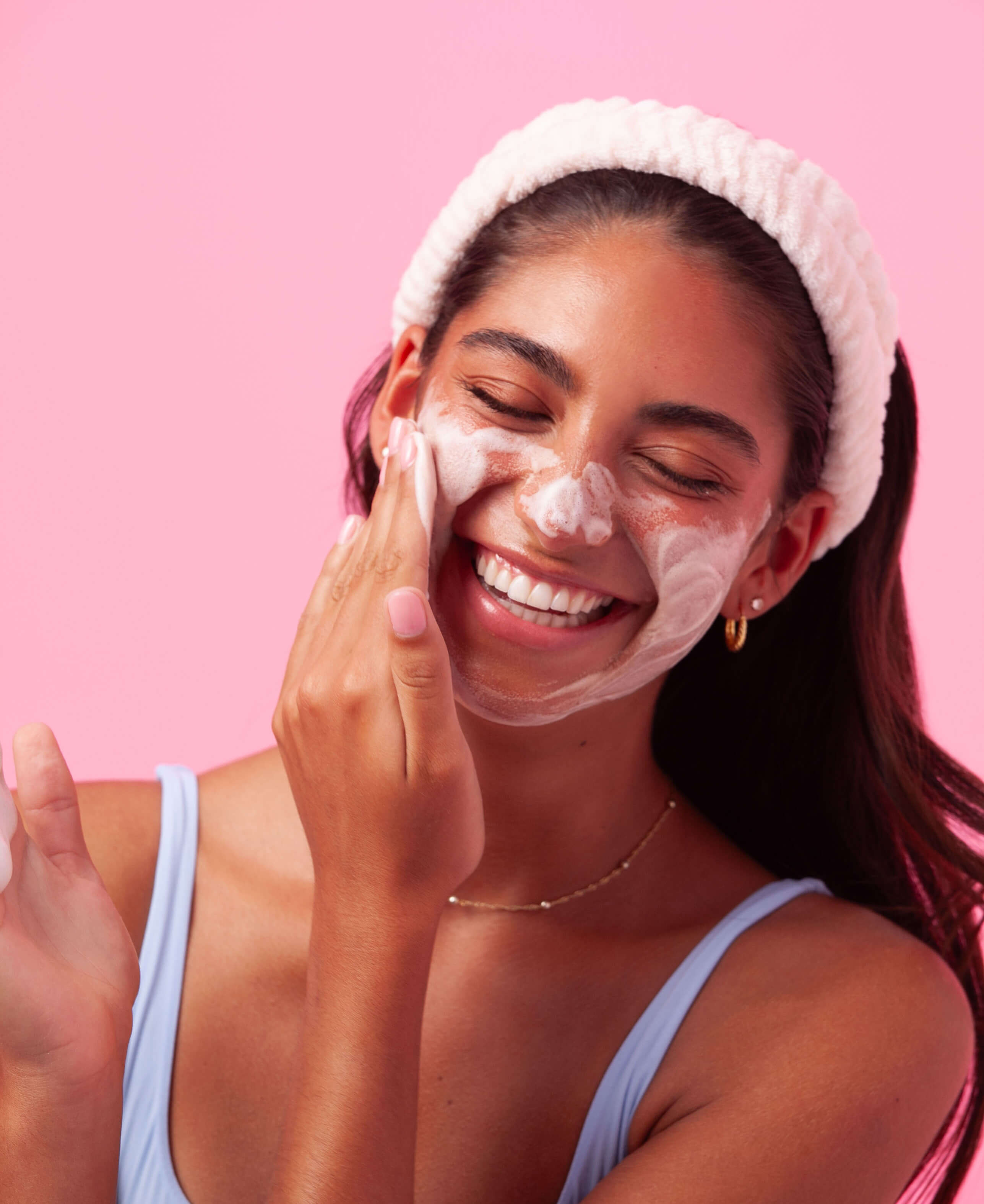 A teen girl washes her face with Fawn Clarity Cloud Cleanser.